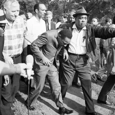 Civil rights protesters, including Martin Luther King, Jr., march toward a realtor's office in 1966