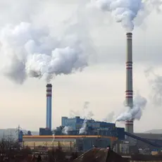 factory with chimneys emitting smoke into the sky