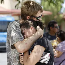 A man hugs a woman tight to his chest.