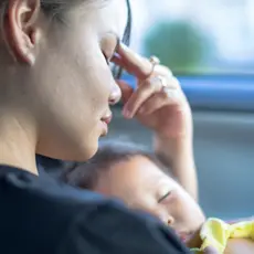 A young woman holds her baby.