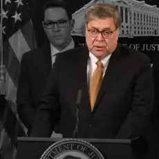 William Barr speaking at a podium