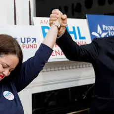 Actor Alec Baldwin holds Amanda Pohl's hand at a campaign event.