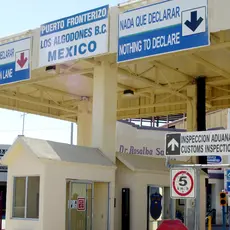 A border control checkpoint with signs in both English and Spanish