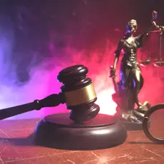 An image of handcuffs, a gavel, and Lady Justice.