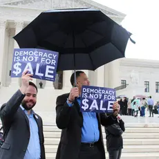 PFAW staff holds signs saying "Democracy Is Not for Sale" in front of the Supreme Court