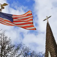 An American flag and a church steeple