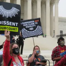 Activists hold signs that read "I Dissent #OurCourt" in front of the Supreme Court.