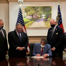 GA Governor Brian Kemp signing voter suppression bill SB202 into law on March 25, 2021