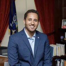 Svante Myrick in a blue jacket posing in an office.