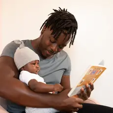 Black father reading to child