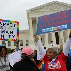 Protestors hold signs supporting LGBTQ rights outside the Supreme Court Building.