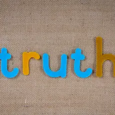 The word "truth" in colorful tiles on a beige background.