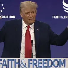 Donald Trump at a podium that reads "Faith and Freedom"