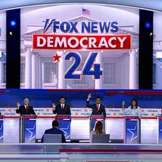 GOP presidential candidates raising their hands behind podiums at the GOP debate.