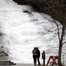 A couple kisses as water gushes down a waterfall at Buttermilk Falls State Park, Monday, Oct. 30, 2017, in Ithaca, N.Y