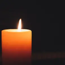 Lit candle in the dark