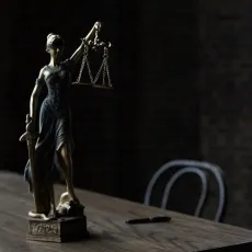 A statue of lady justice sitting on a table.