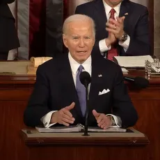 President Joe Biden stands at podium delivering the 2024 State of the Union address.