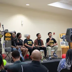 4 panelists on a stage at a Black History Month event.